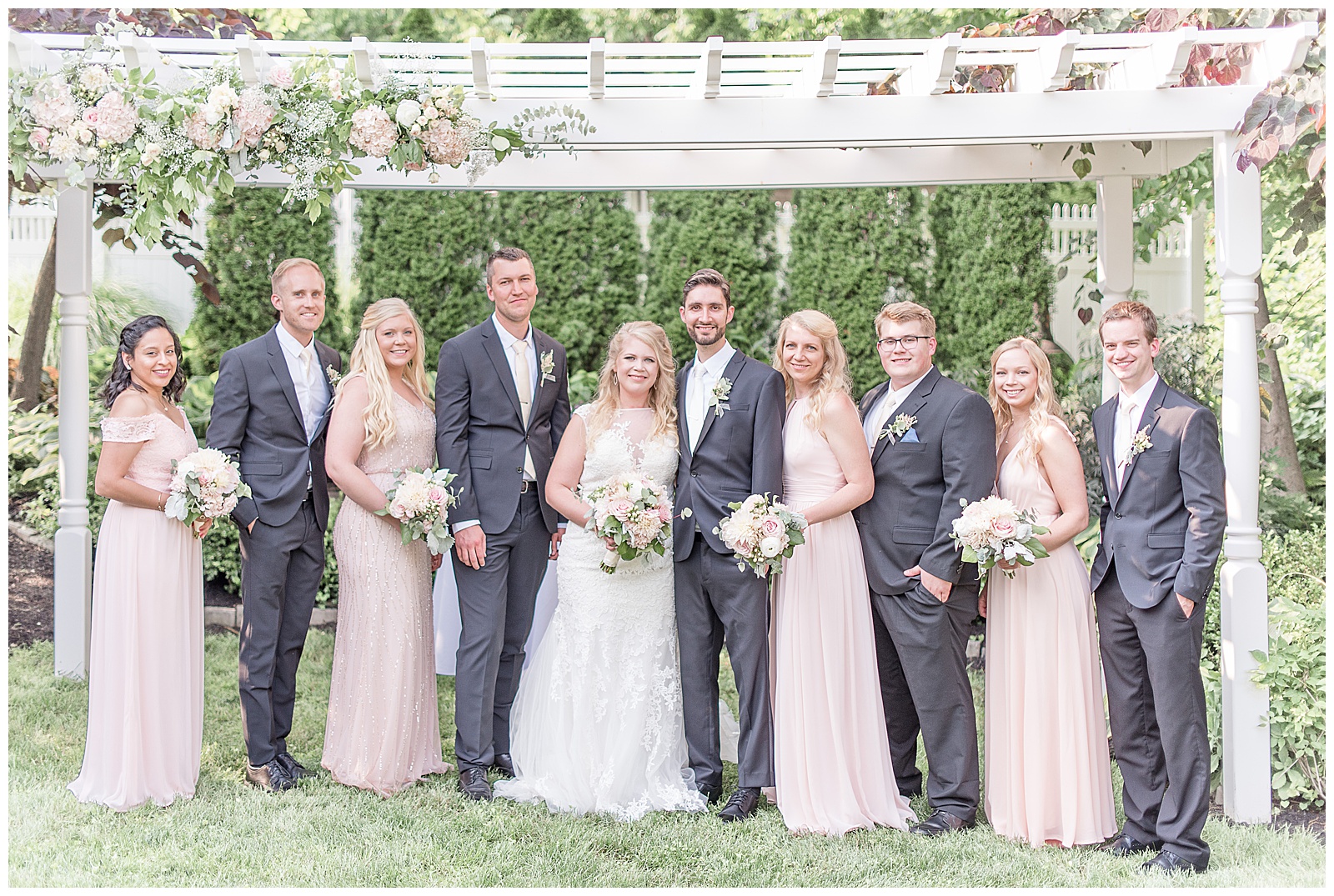 bridal party in front of arbor