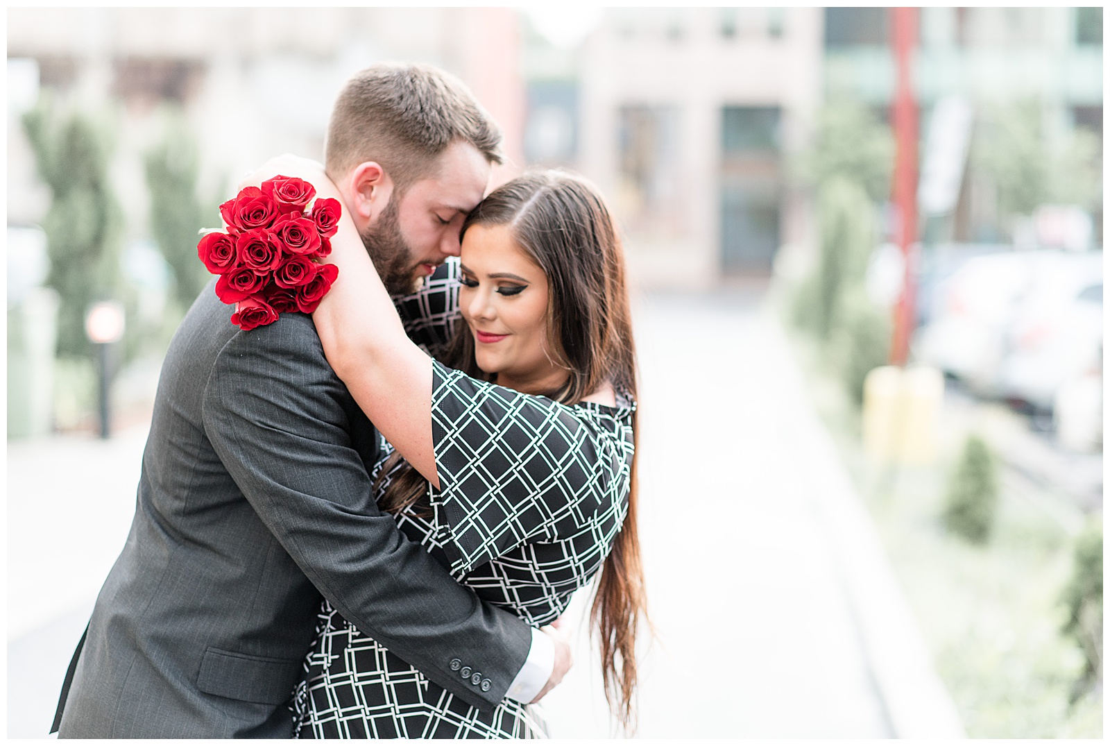 girls arms wrapped around guys neck with roses in hand