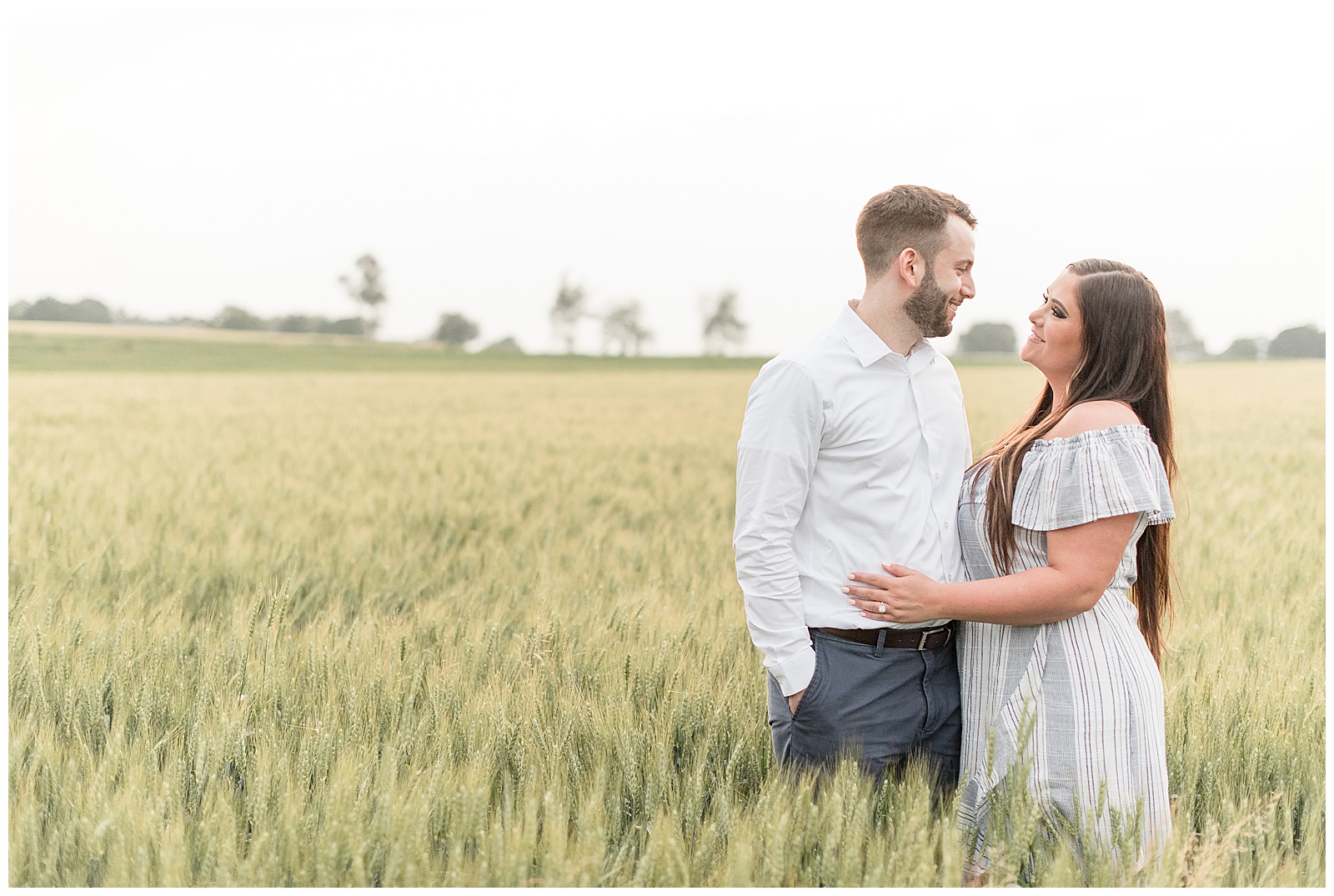couple looking at each other in a wheat field