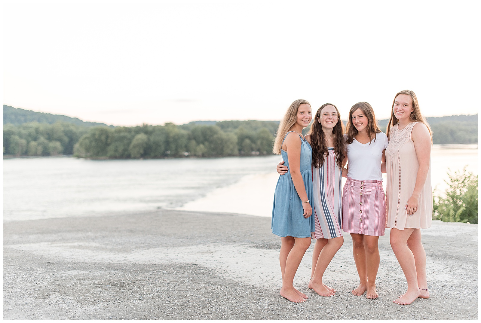 four seniors standing and smiling at camera with arms around each other at the white cliffs of conoy