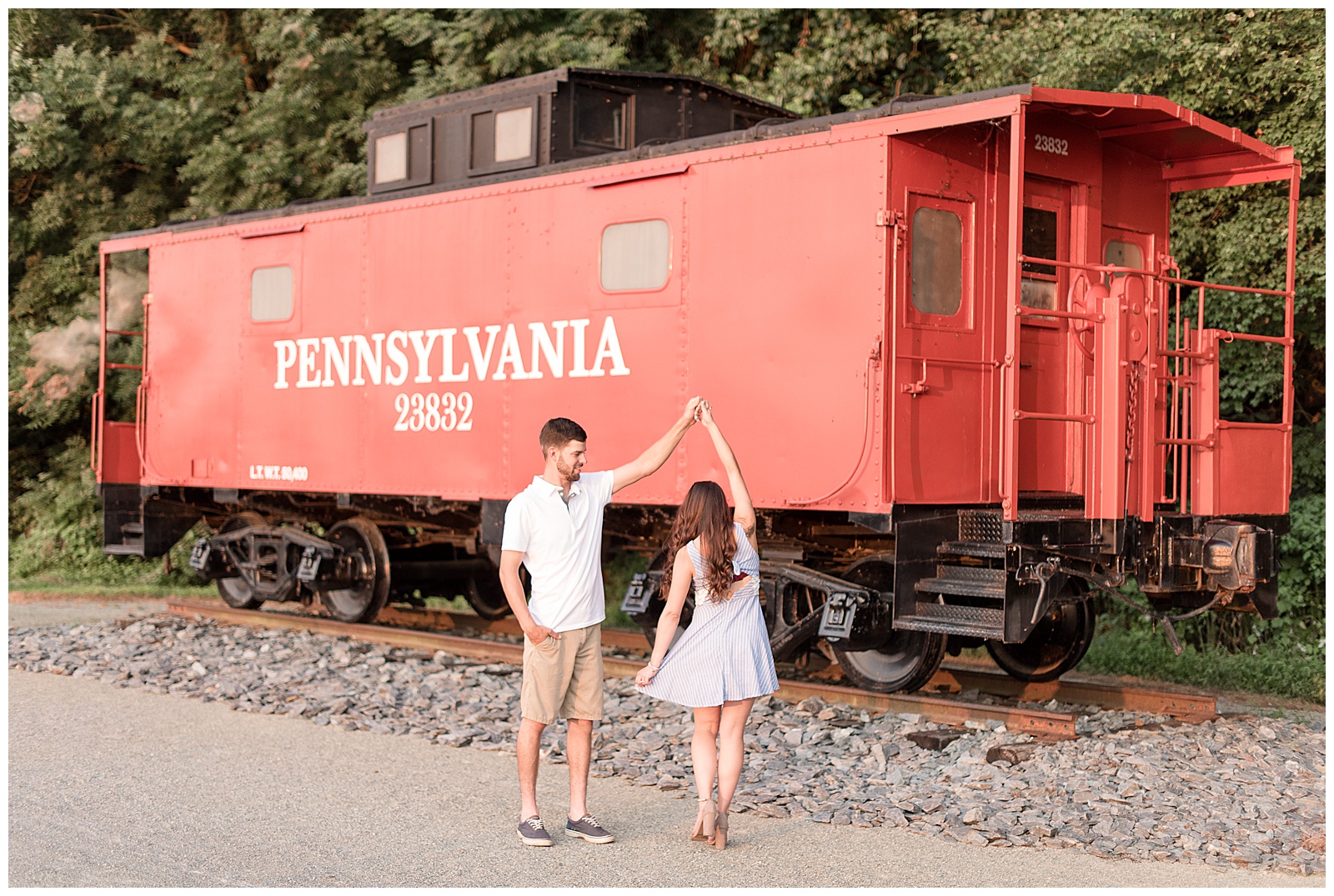 couple twirling in front of red caboose