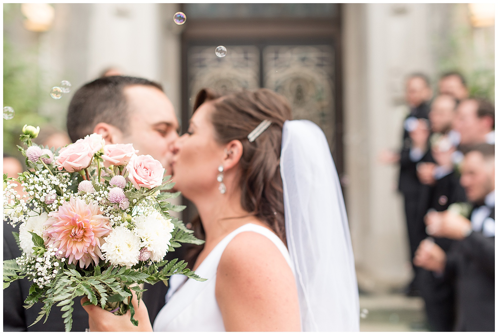 bride and groom kissing outside Sacred Heart Church