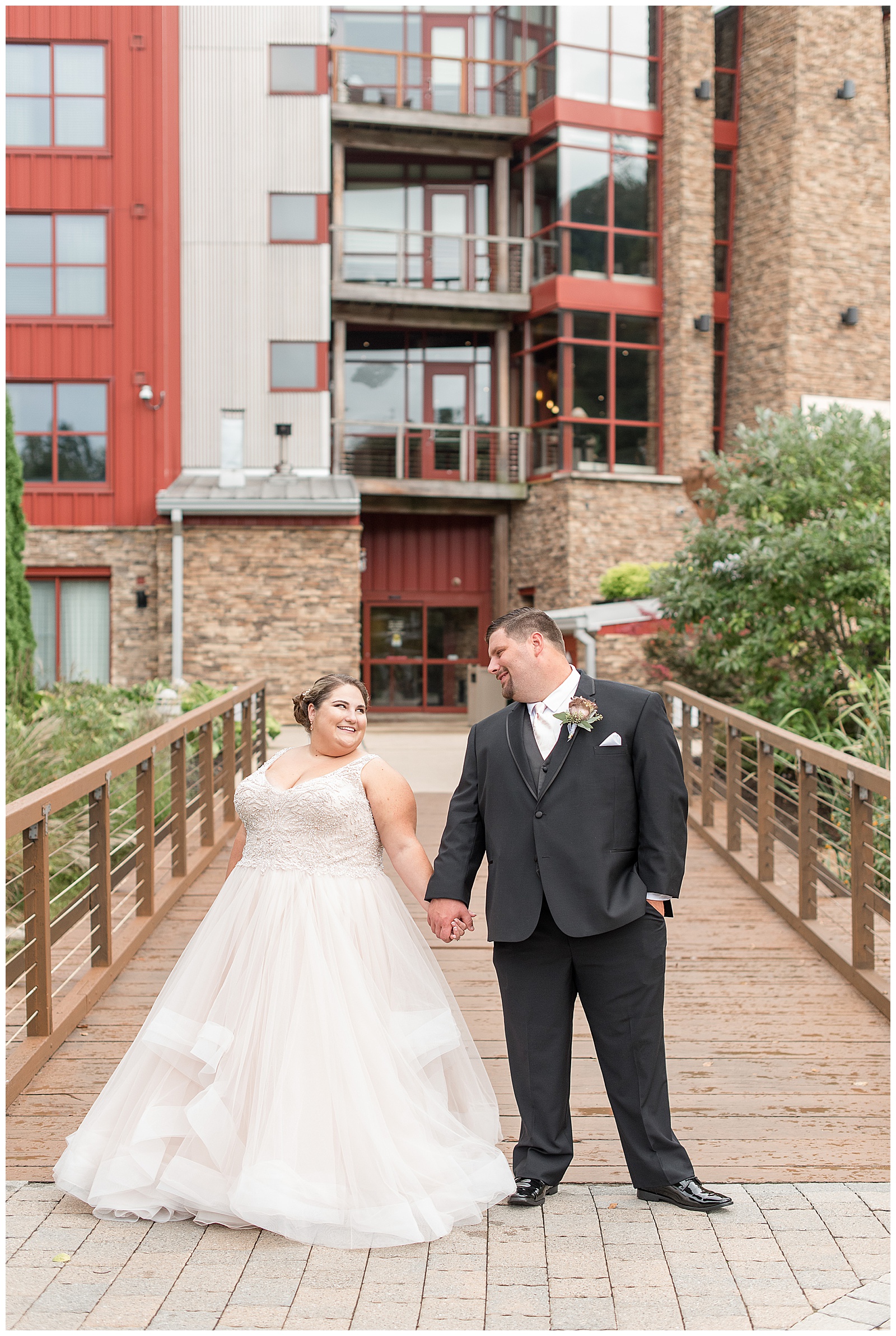 bride and groom hand in hand in front of Bear Creek Mountain Resort