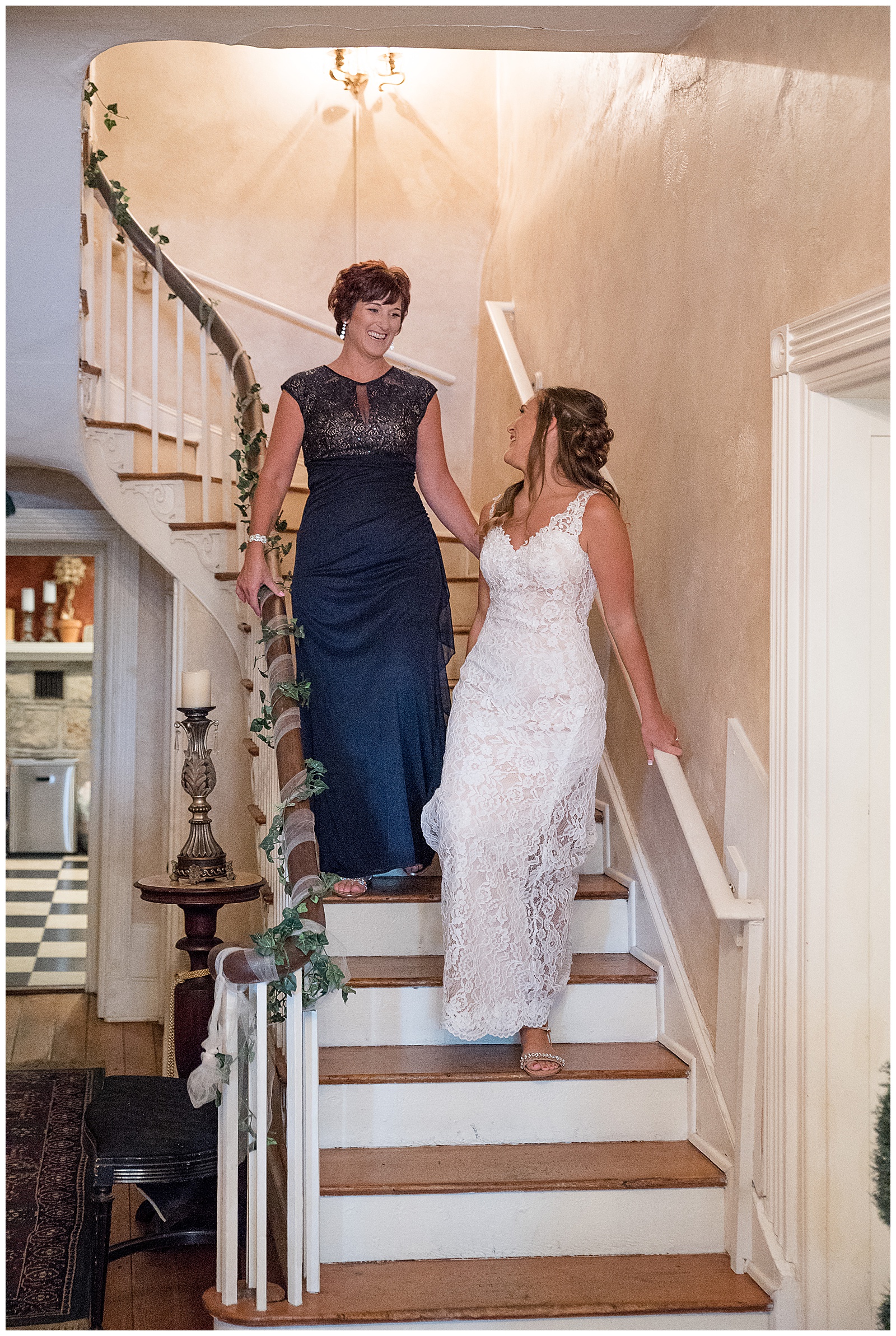 bride walking down stairs and looking up at her mom