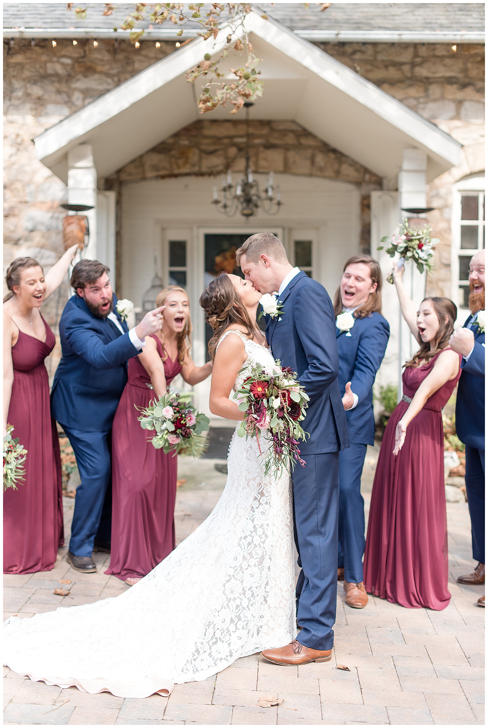 bride and groom kissing with bridal party cheering behind