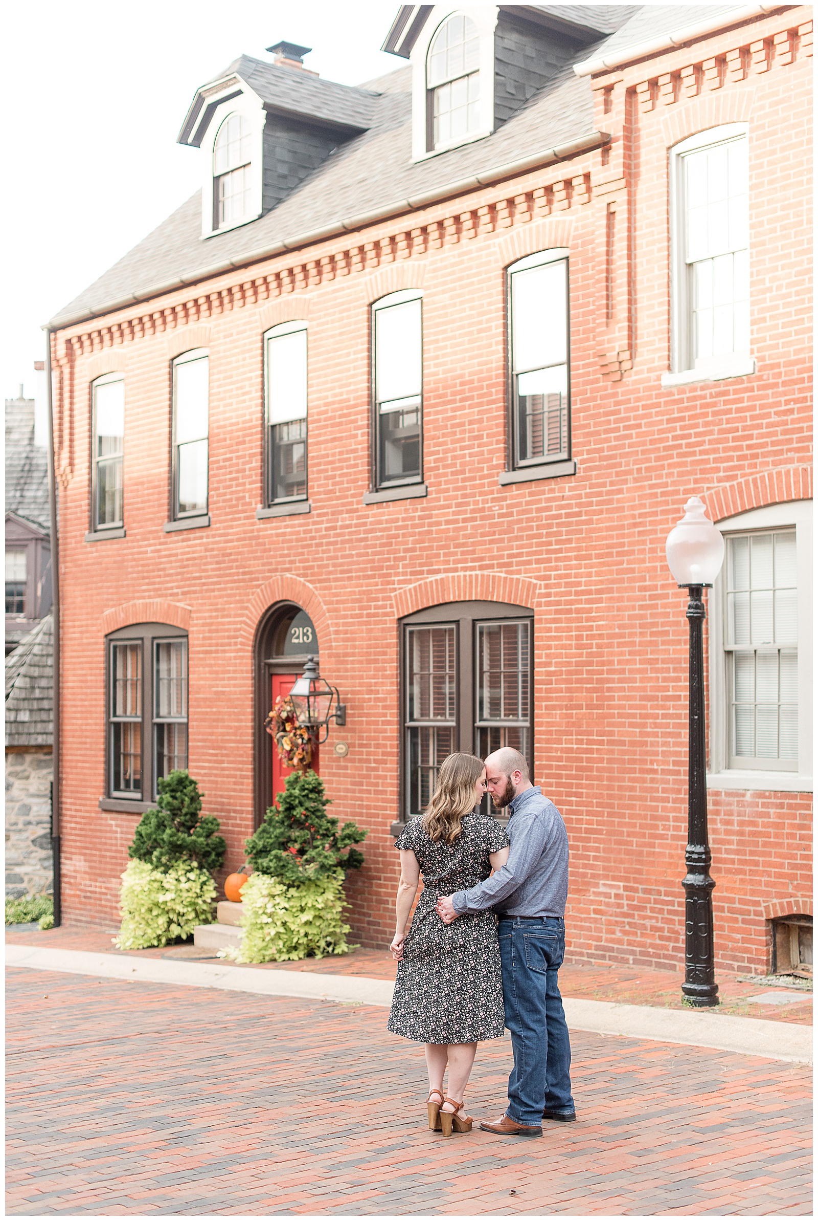 couple in front of cute brick house looking at each other