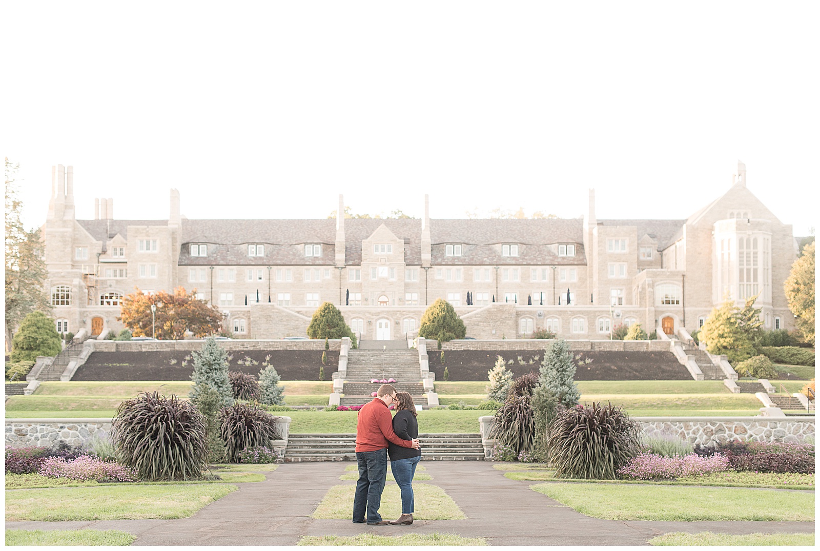 couple kissing at engagement session in formal gardens at Masonic Village