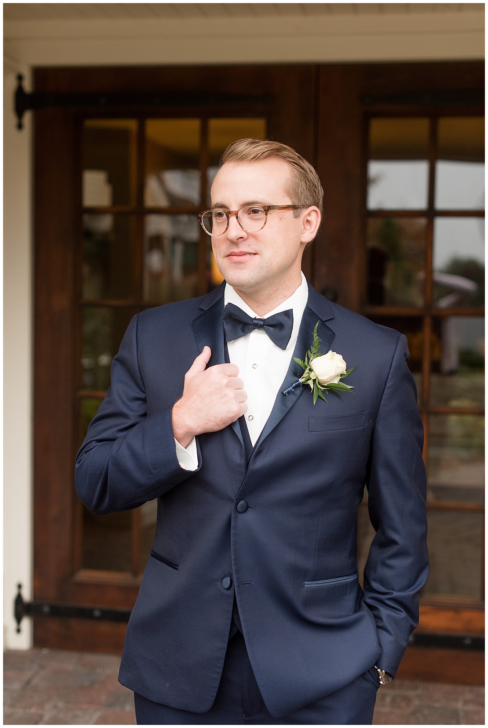 groom portrait-holding lapel and smiling off camera