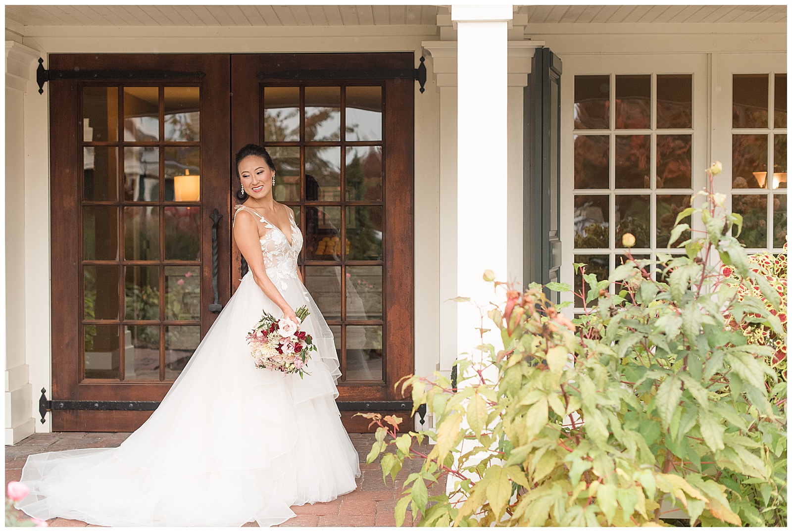bride smiling off camera to left with flowers down by her side at the Inn at Leola Village