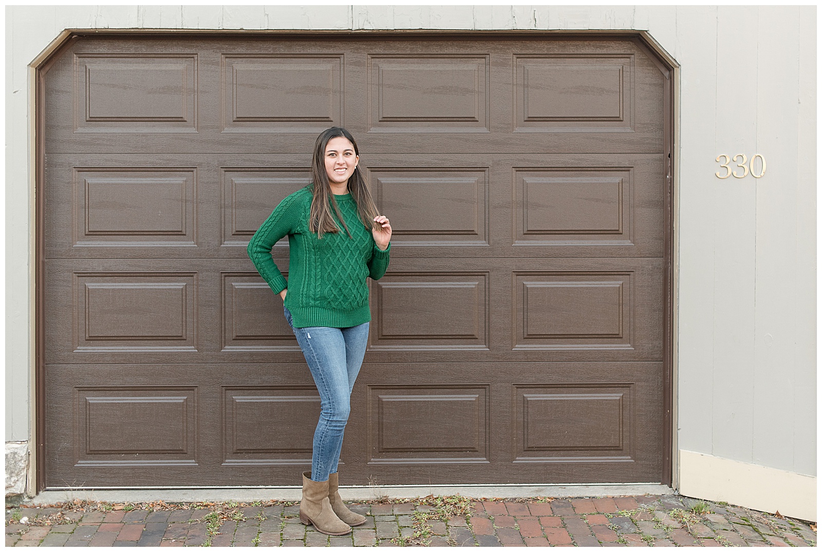 senior girl standing in front of brown garage door