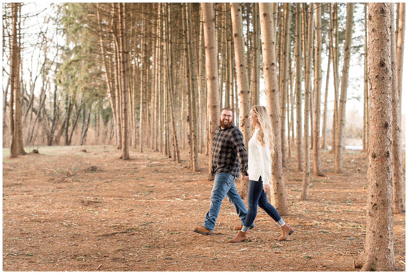 couple walking among a forest of pine trees