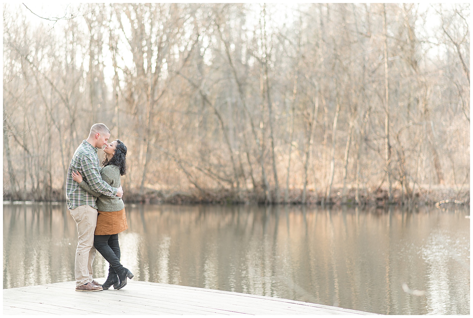 couple wrapped up in each other's arms on a wood dock