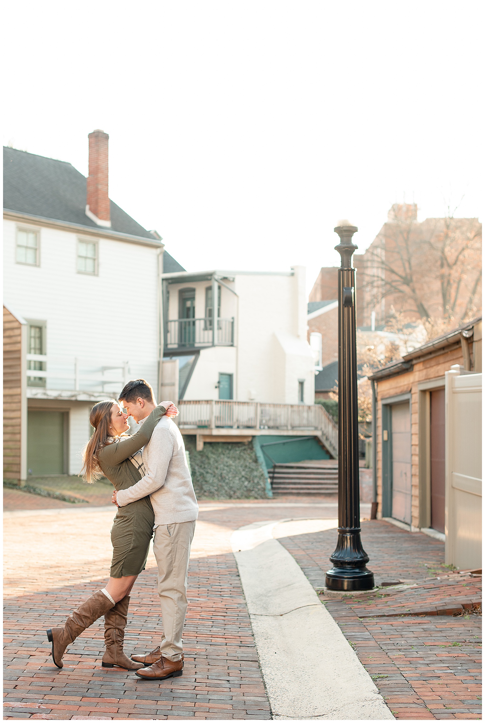 couple kissing in middle of street with lamp post to the side