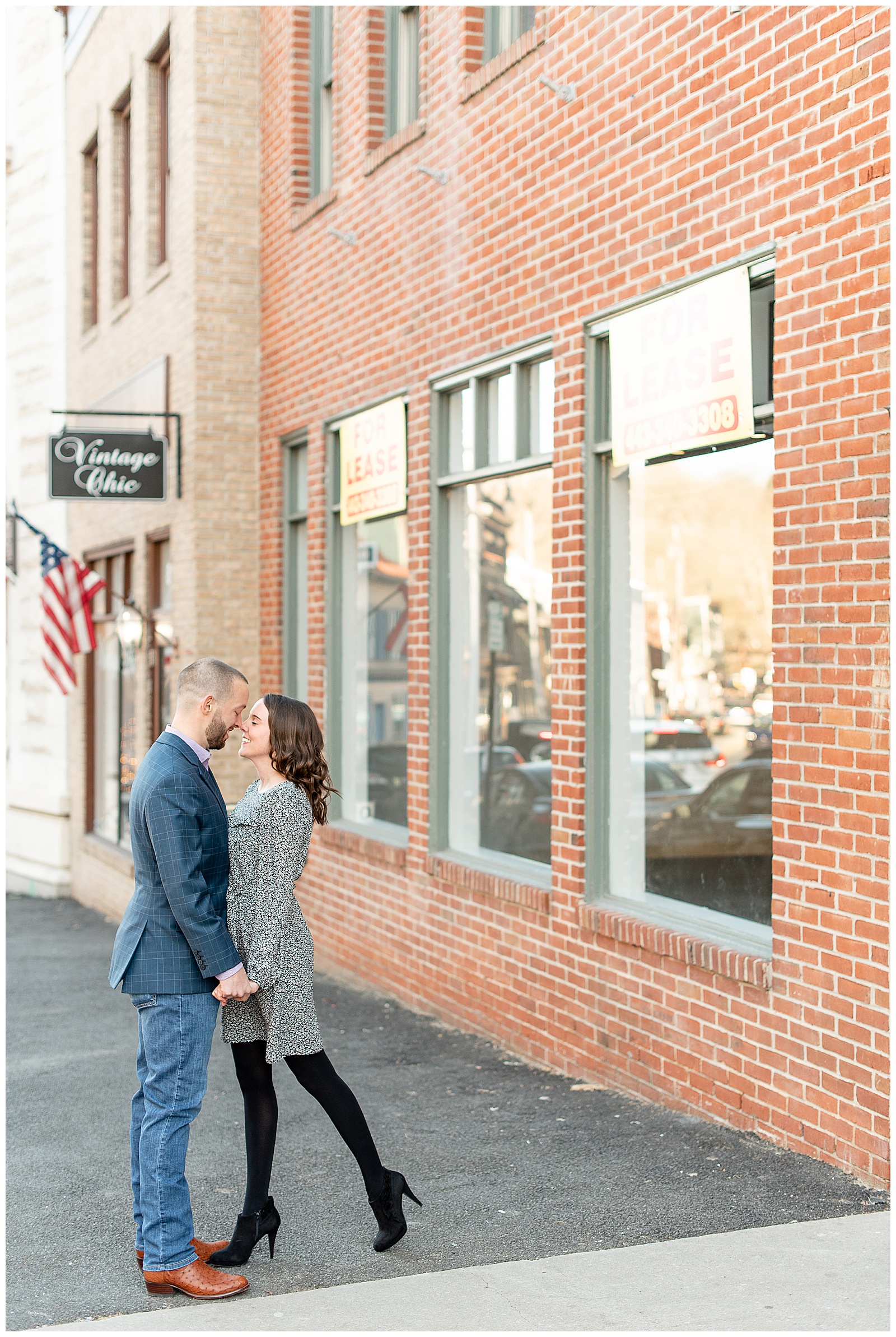 couple coming together to share a kiss downtown in Ellicott City