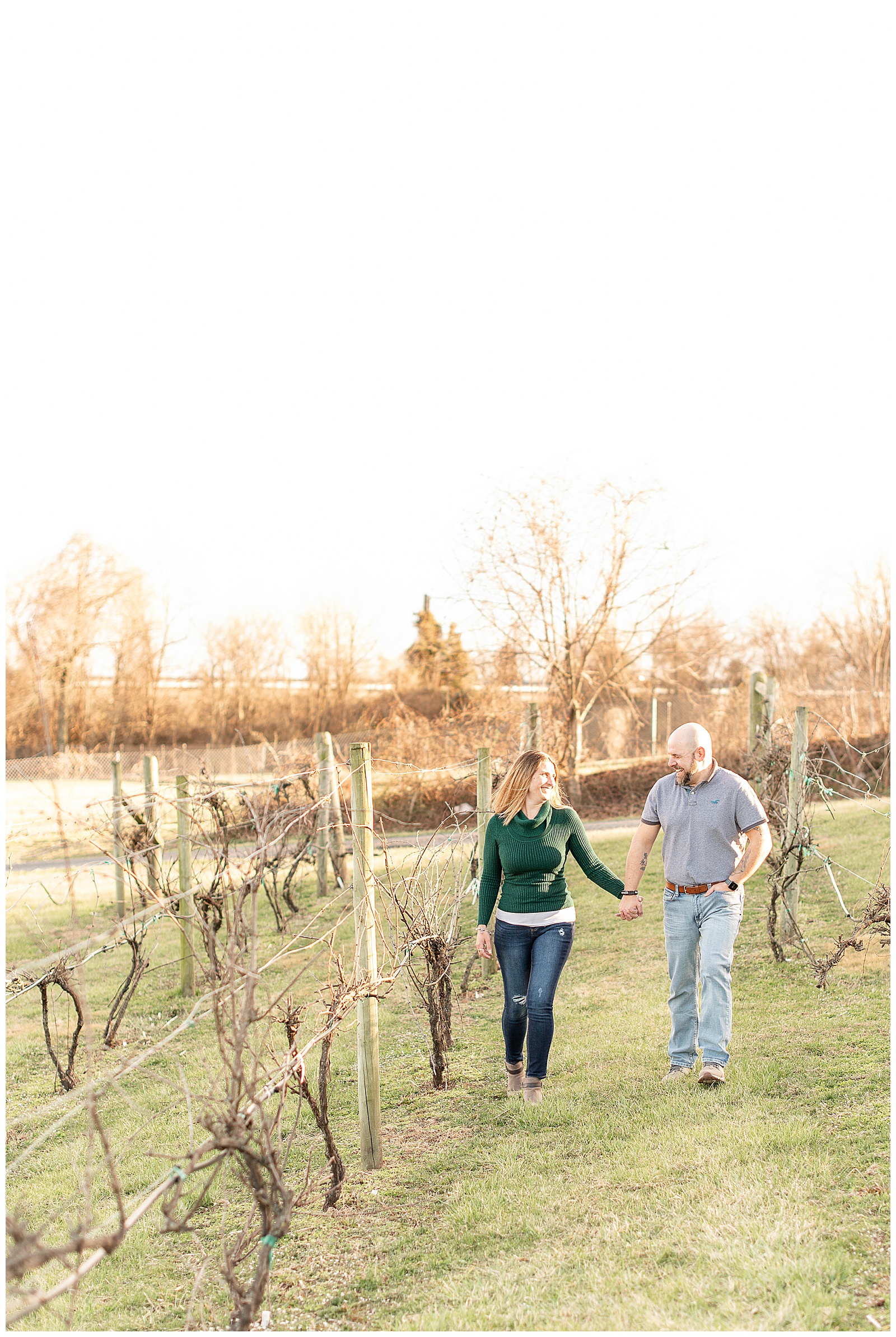 couple walking hand in hand along the vineyards in March