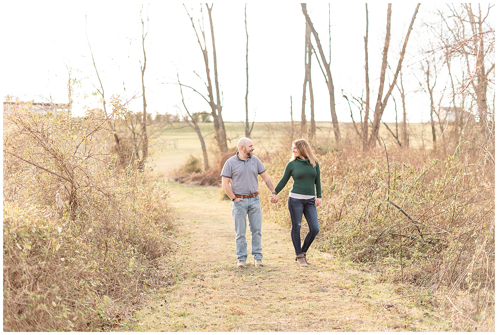 couple standing and looking at each other along grass path