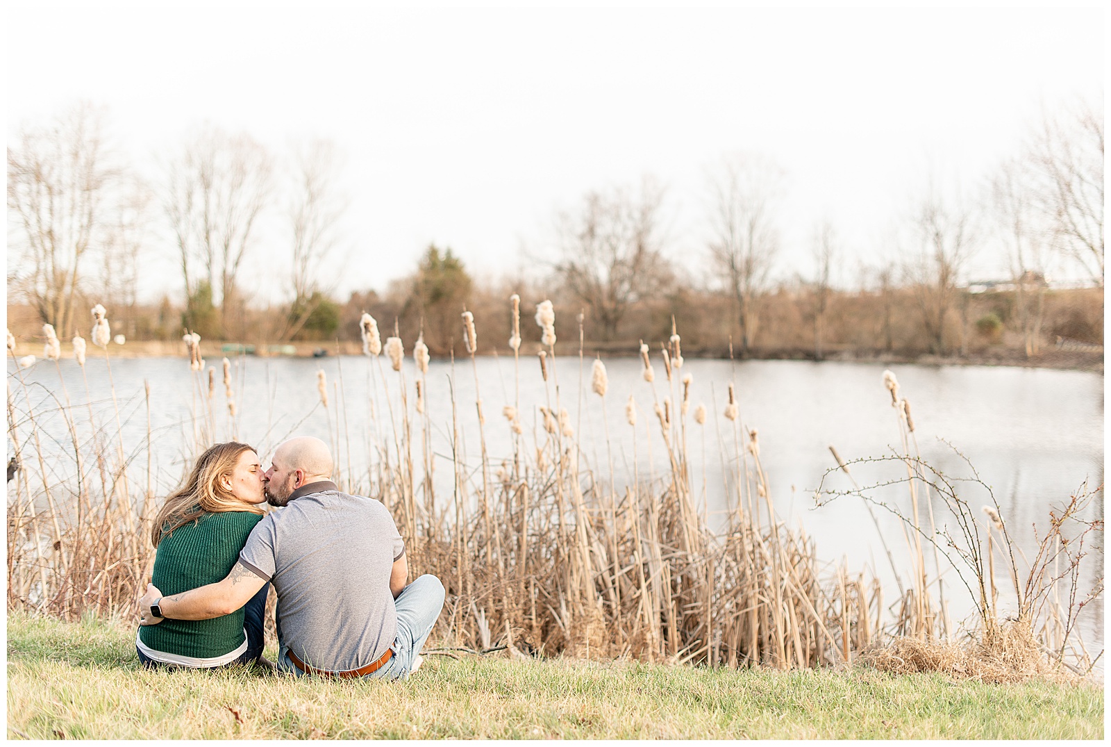 couple kissing along pond for engagement session