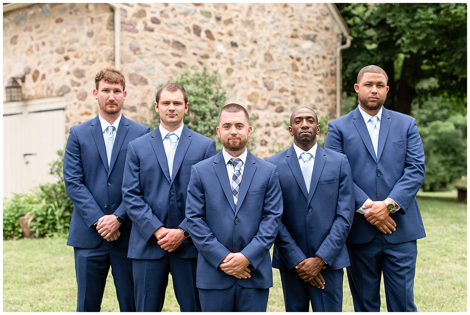 groomsmen standing and staring at camera with straight face
