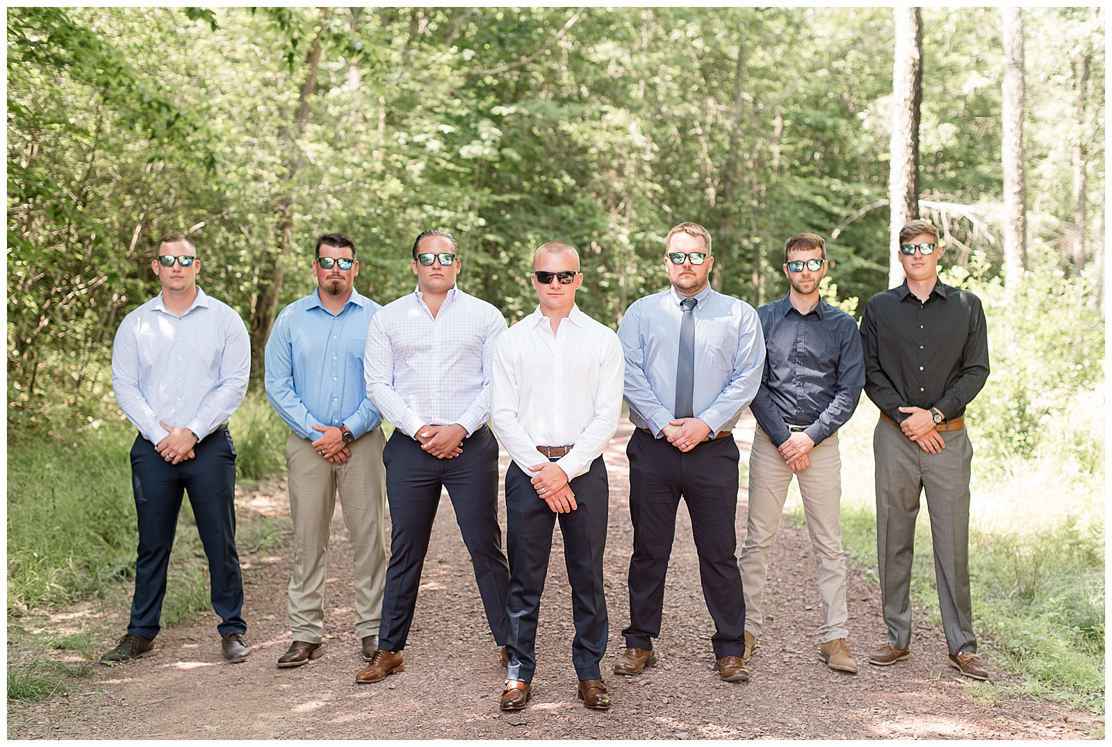 groomsmen all wearing sunglasses staring at camera in a flying v formation