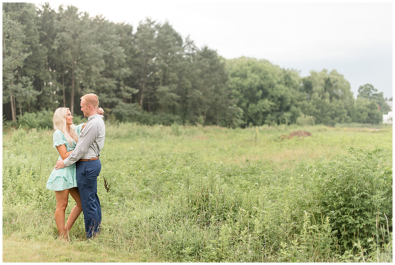 couple standing in olooking at each otherpen grass field 