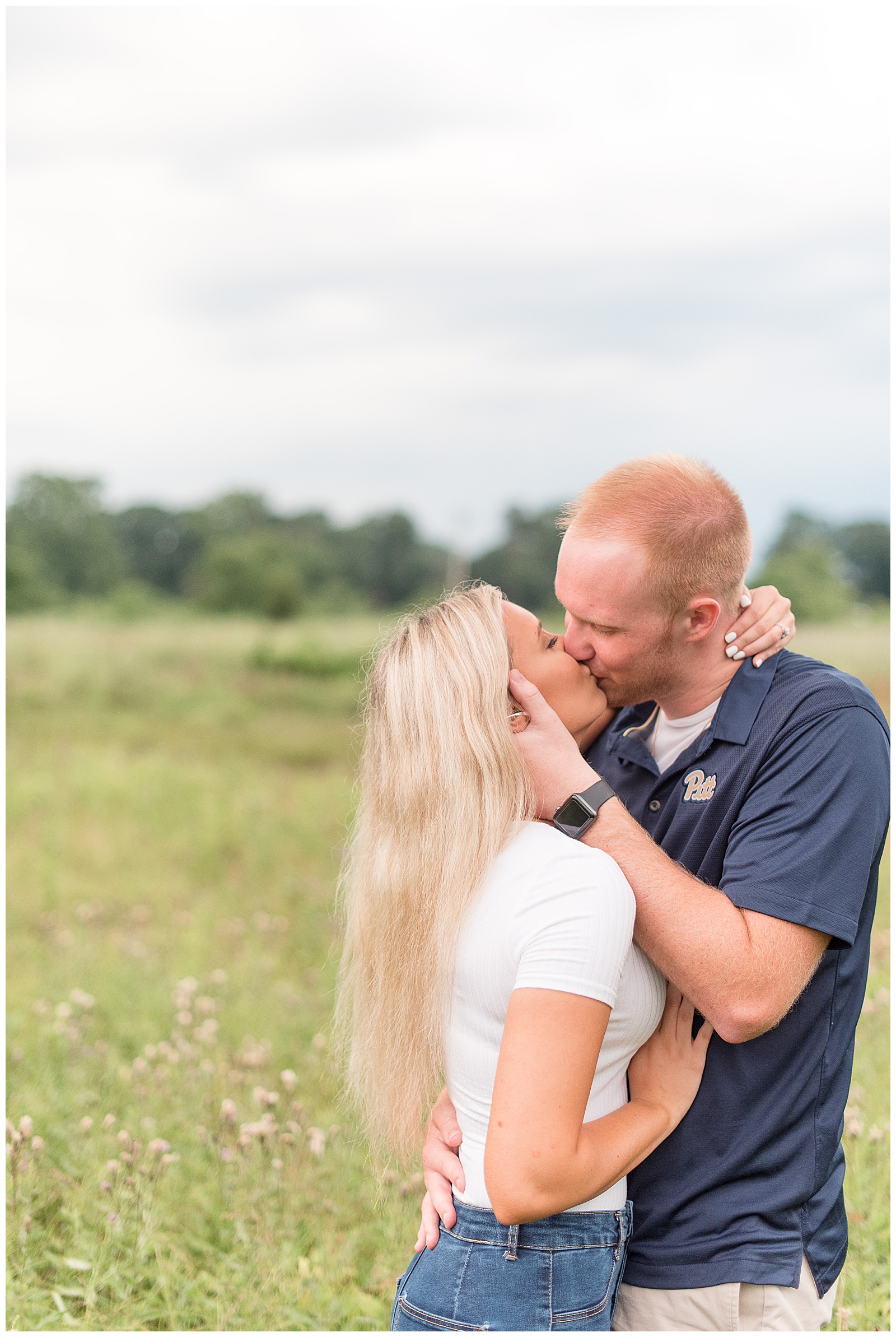 couple kissing in wild field at Overlook Park for engagement session