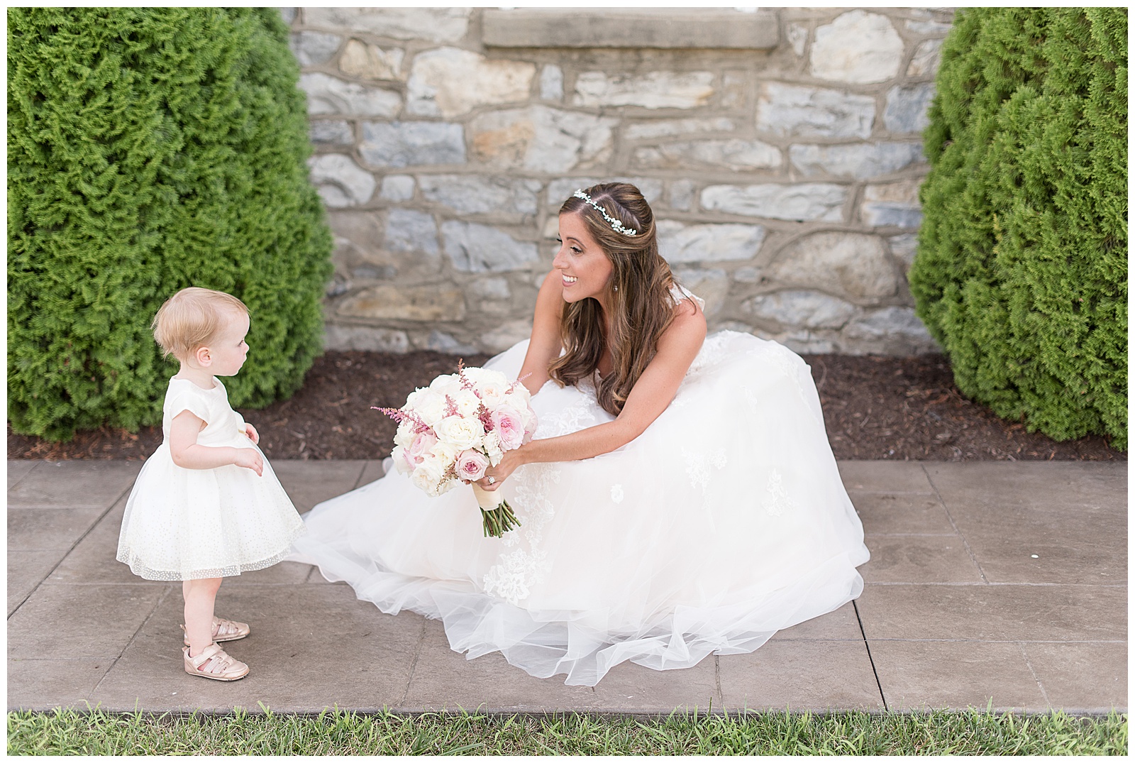 bride showing flowers to flower girl