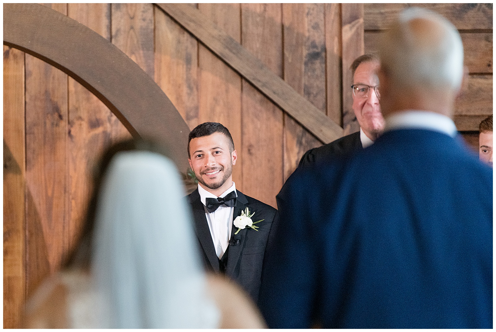 groom smiling as bride and dad walk down the aisle towards him