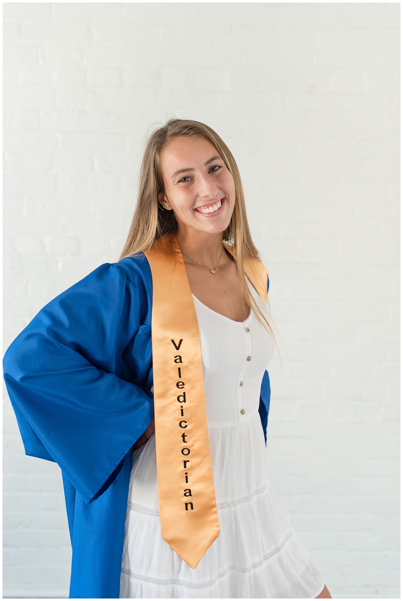 senior smiling for cap and gown session at Hinge works