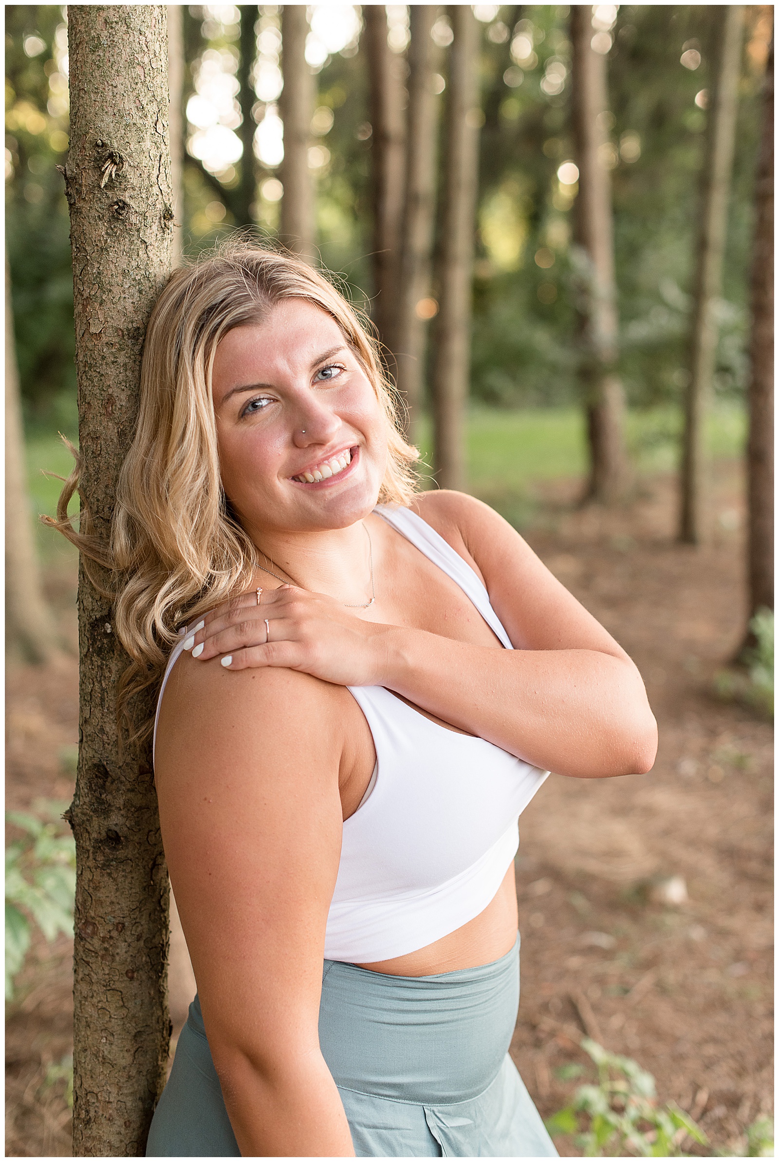senior session as she leans back on a tree smile to the camera