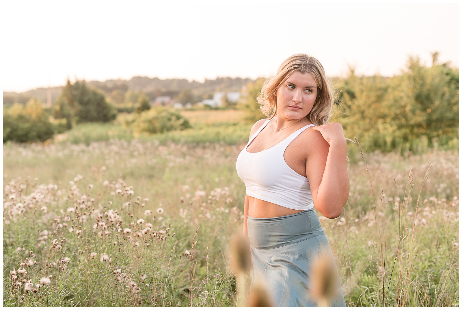 senior looking slightly off screen with tall grasses all around her for senior session at Overlook Park