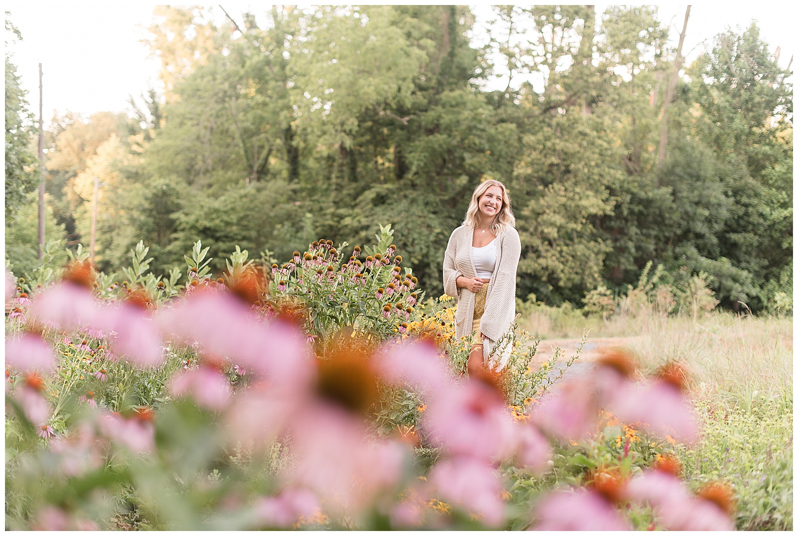 senior smiling over shoulder with flowers all around her