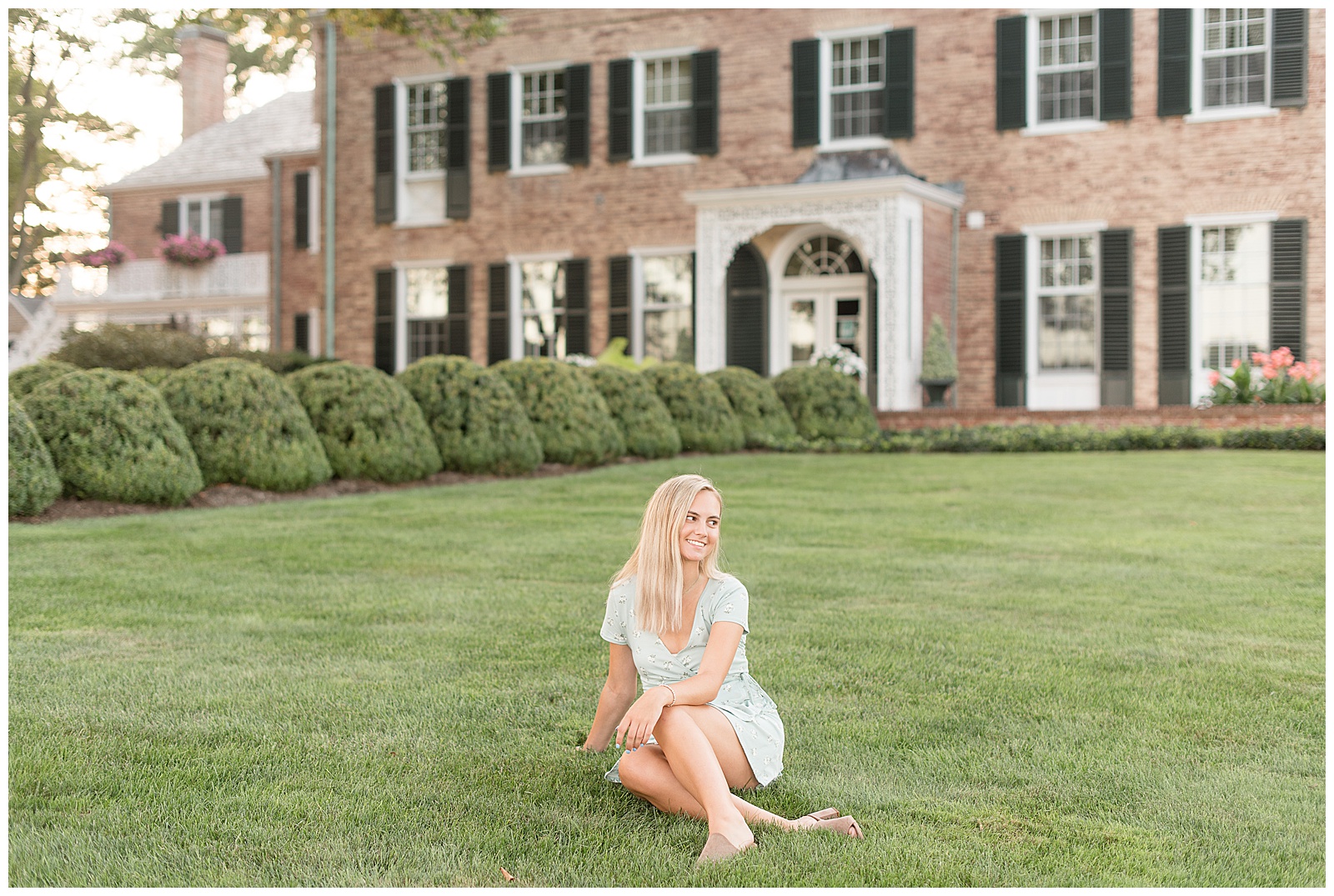 senior sitting on lawn in front of main brick house at Drumore Estate