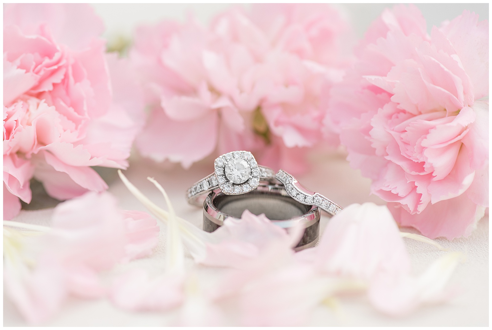close up photo of the bride's diamond ring surrounded by pastel pink flowers at Lakefield Weddings in Manheim, PA