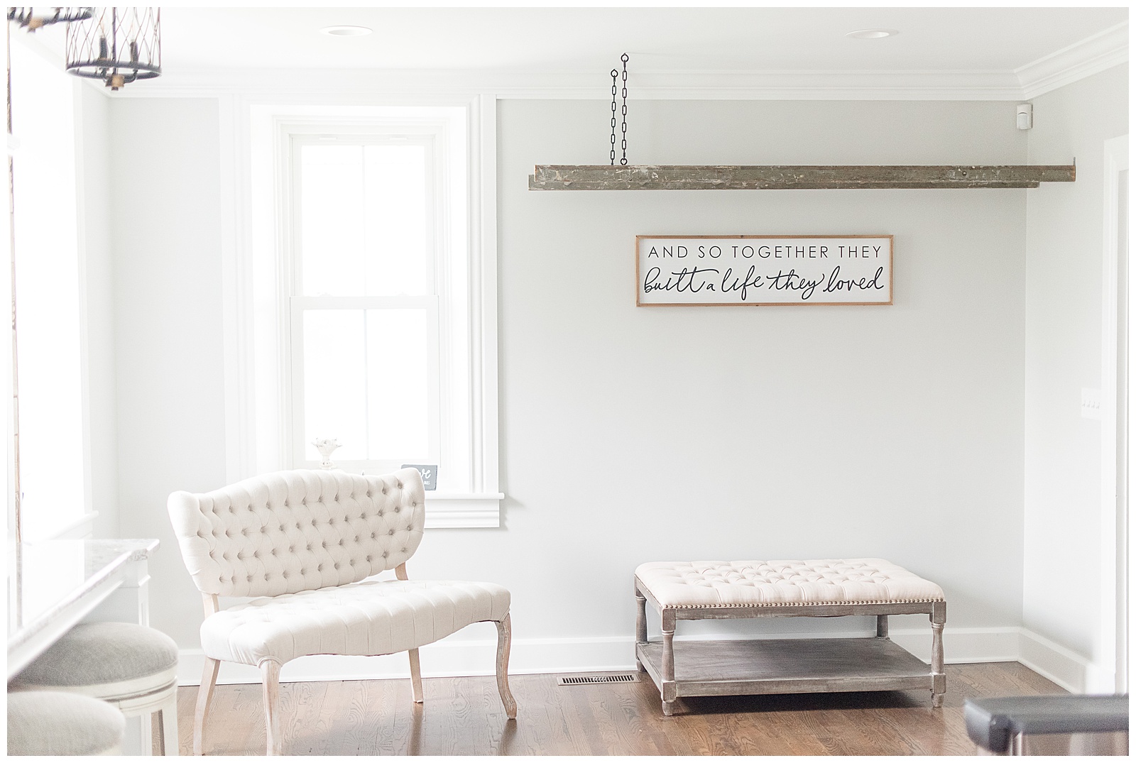 interior photo of room with light gray walls and large white window on the left side of photo with beautiful white settee in front of window and dark gray bench along wall with rustic wooden ladder hanging above bench with wooden worded wall art displayed between the bench and the ladder at Spring Valley Farms in Dover, PA