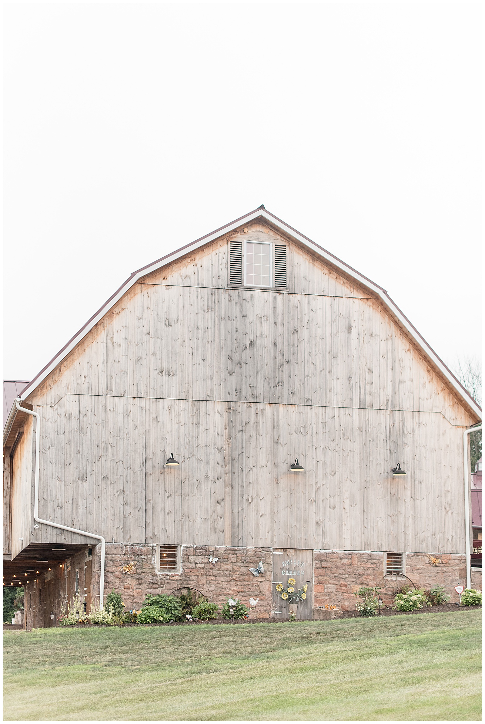 close up photo of side of rustic faded ivory barn with sandstone along bottom at Spring Valley Farms in Dover, PA