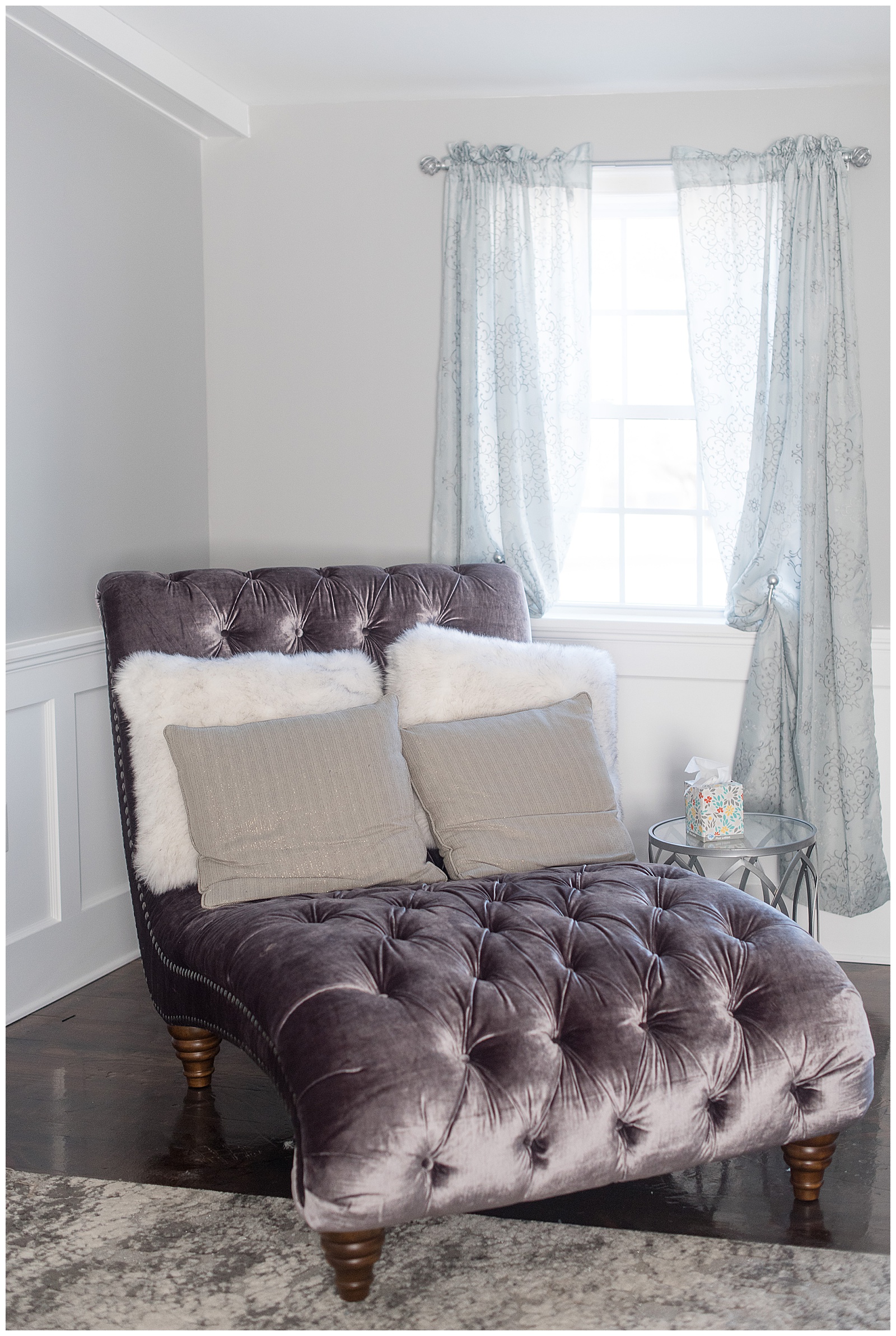 close up photo of dark brown leather chaise lounge with white and gray pillows in corner of gray room with large bright white window behind chair at The Barn at Stoneybrooke in Atglen, PA