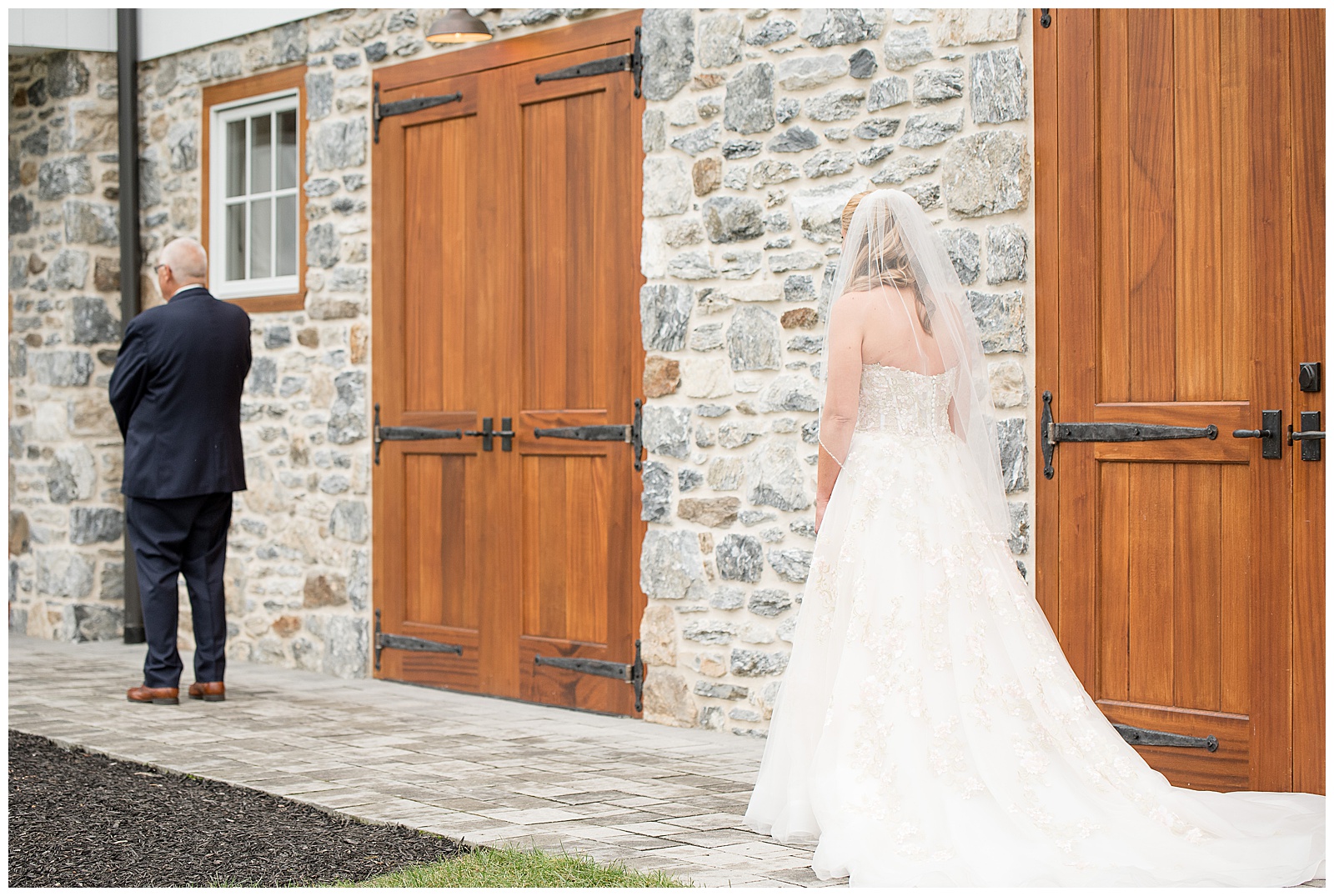 bride in gown approaching her father for first look outside barn at bluestone estate