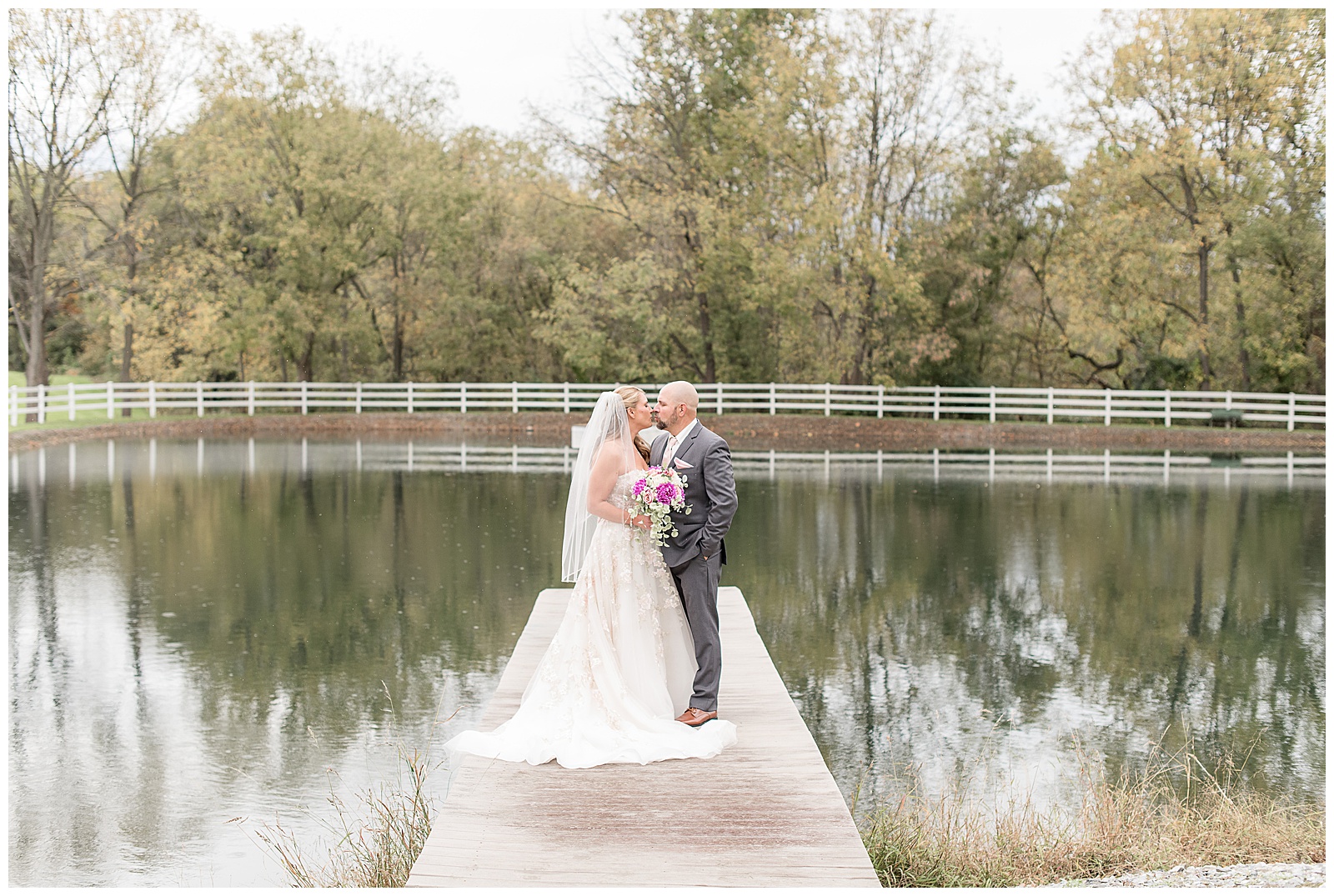 bride and groom almost kissing on dock by pond on beautiful fall day at bluestone estate