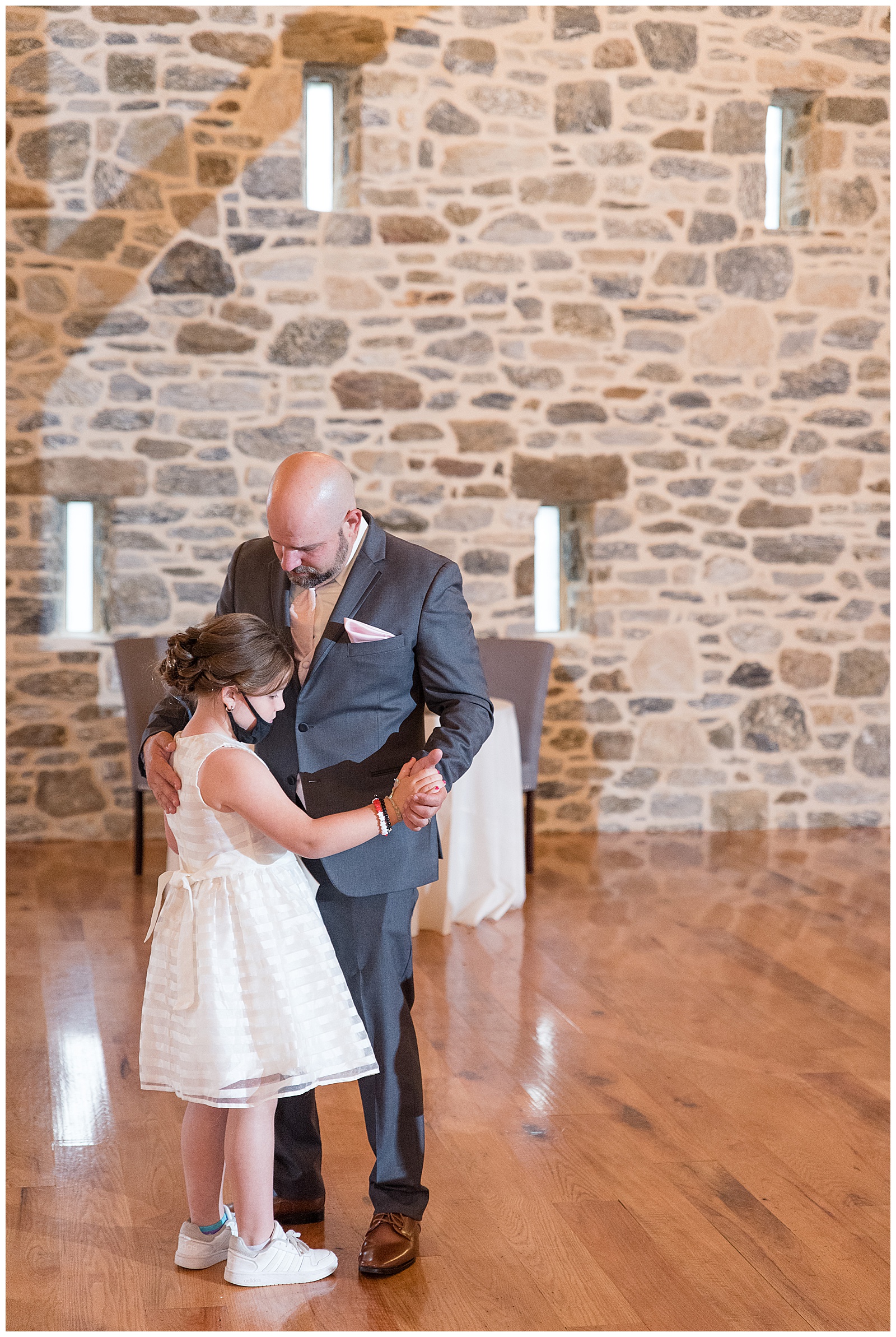 groom slow dancing with daughter during reception in stone barn in lancaster pennsylvania