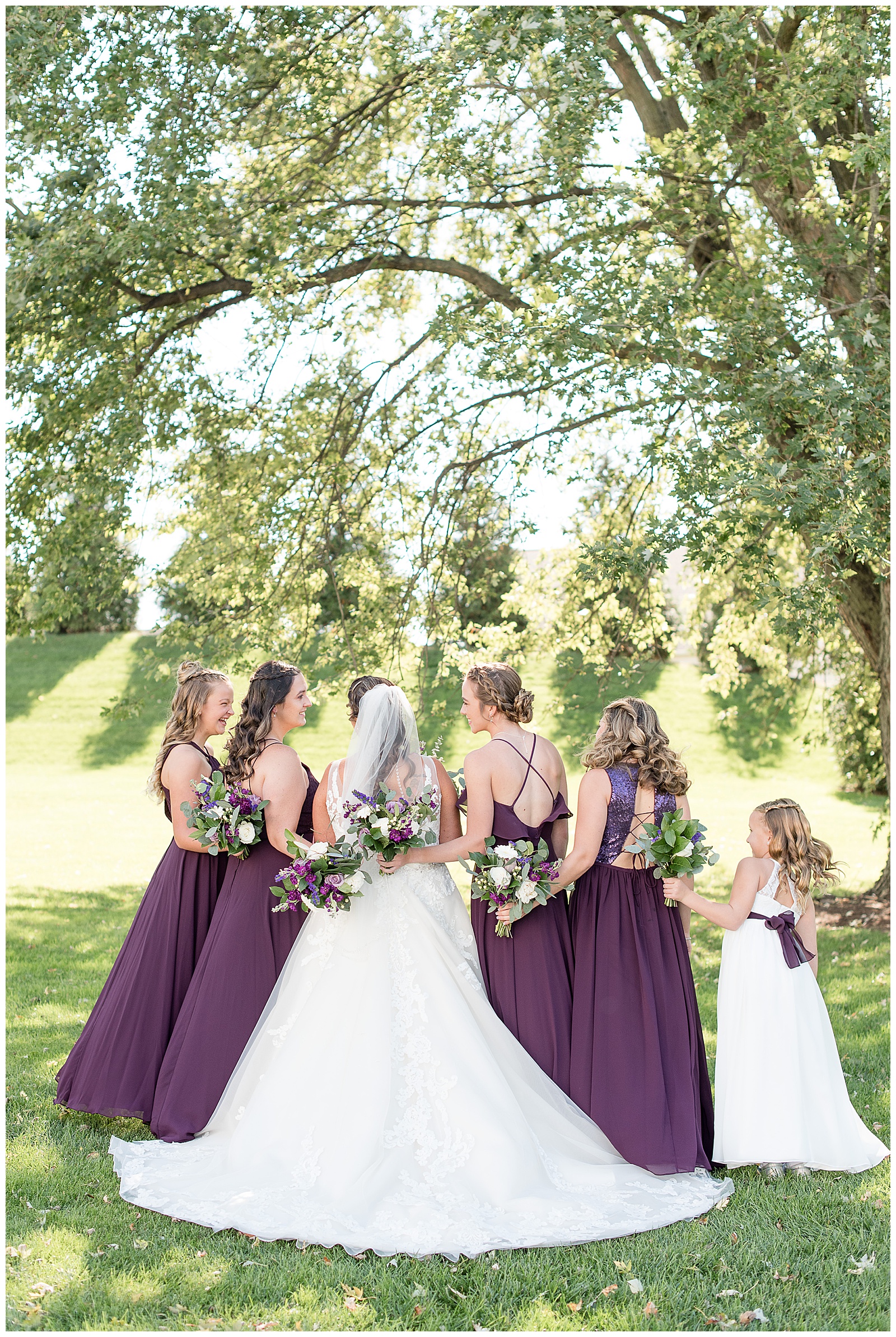 bridesmaid photo of back of dresses while girls are smiling at each other