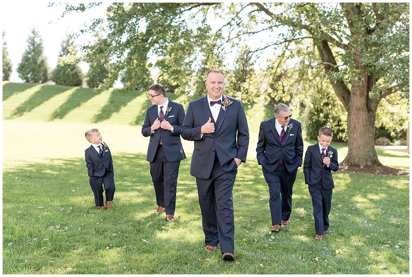 groomsmen all walking toward camera and talking to each other and smiling