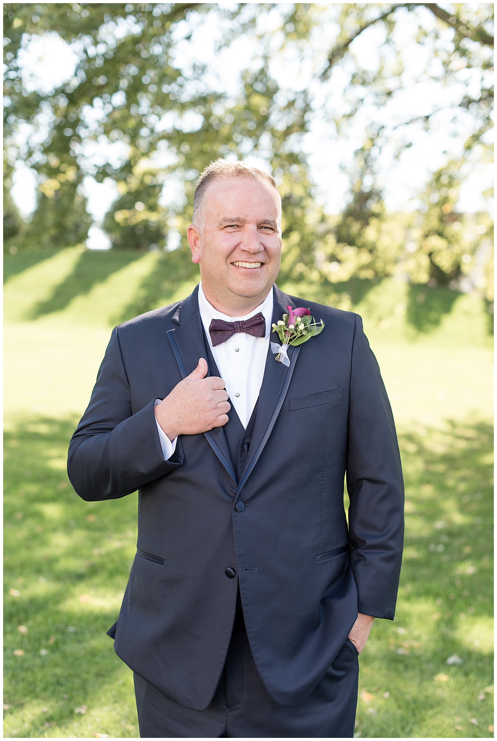 groom portrait smiling at camera holding on to lapel