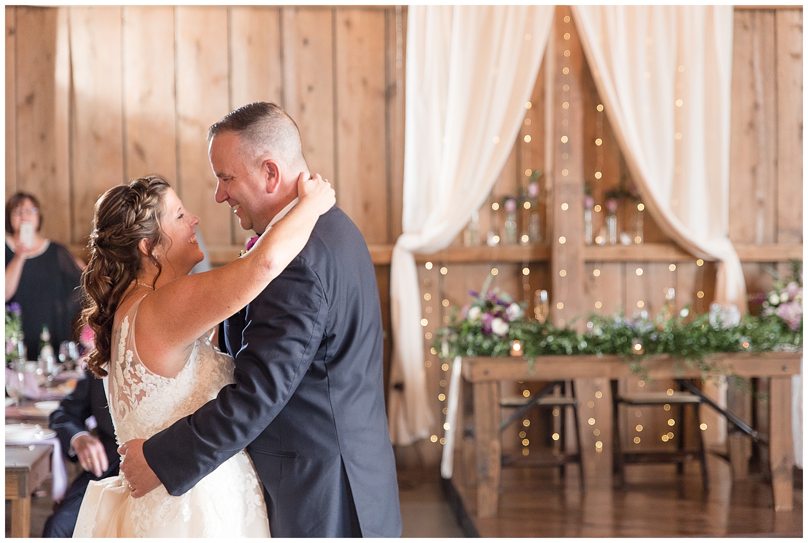 bride and groom smiling at each other while sharing first dance in front of sweet heart table at Stoltzfus Homestead and Gardens