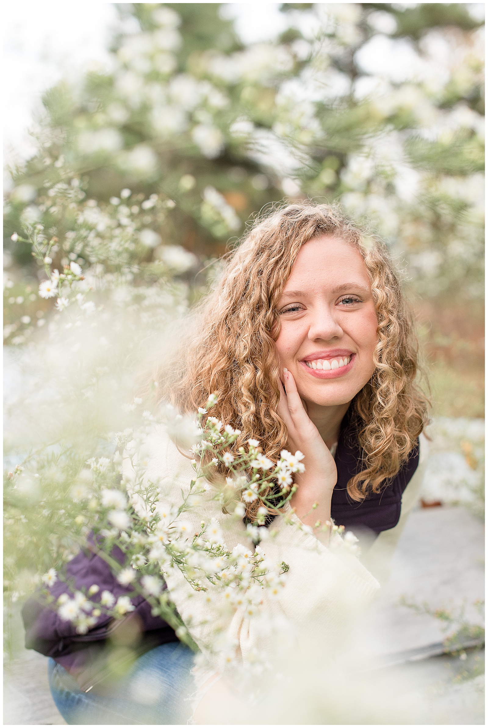 senior girl behind white wildflowers on fall day in lancaster pennsylvania