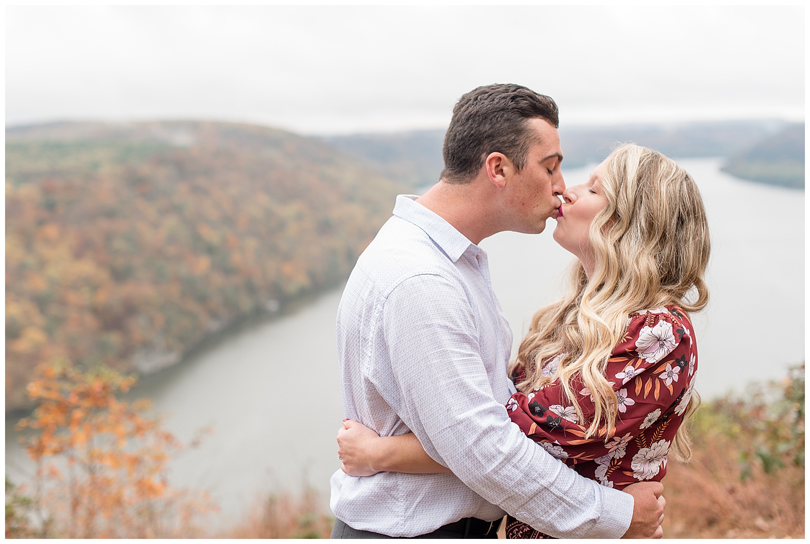 couple hugging and kissing next to colorful trees atop pinnacle point in holtwood pennsylvania