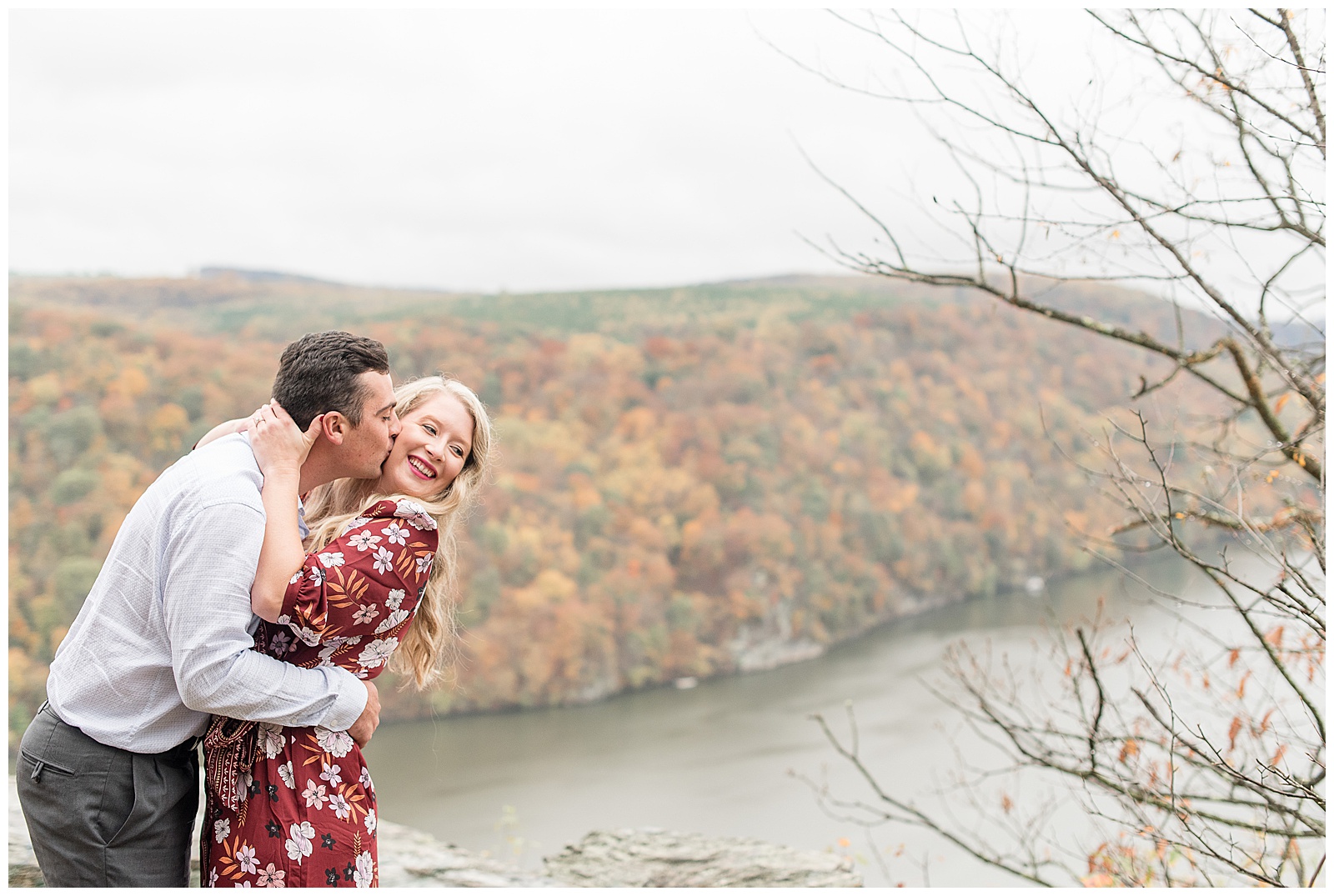 guy kissing girl and hugging tightly atop pinnacle point on colorful fall day in lancaster pennsylvania
