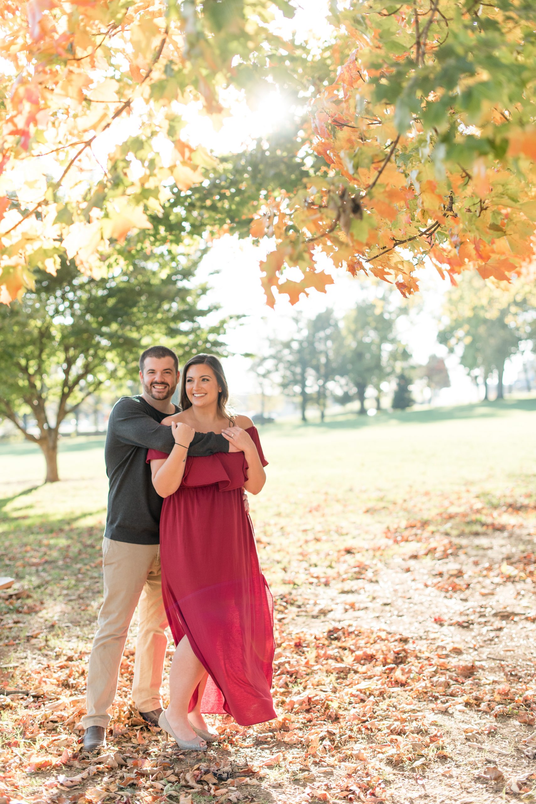 guy hugs girl under beautiful tree on sunny evening in lancaster pennsylvania