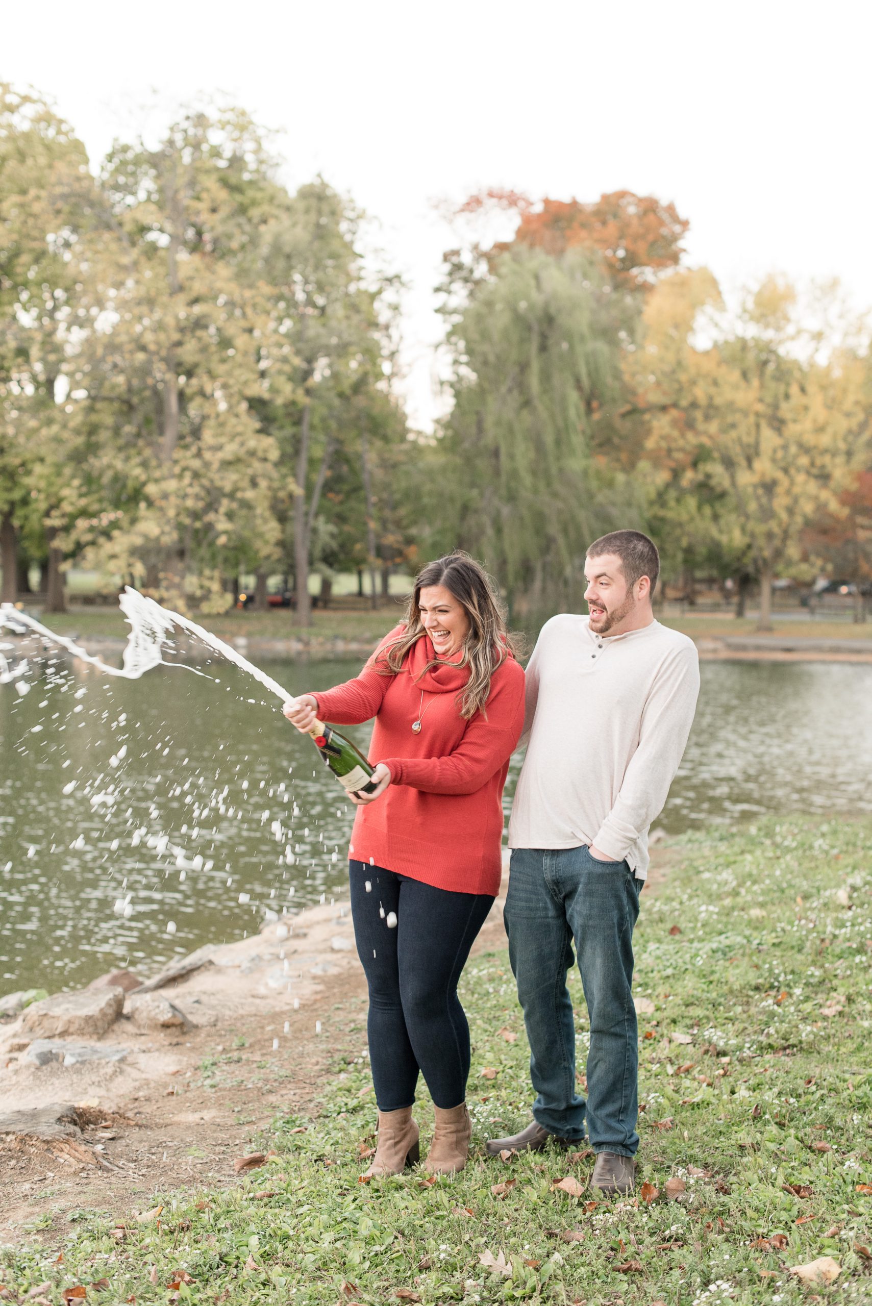 couple smiling while girl pops cork and wine bottle sprays at longs park
