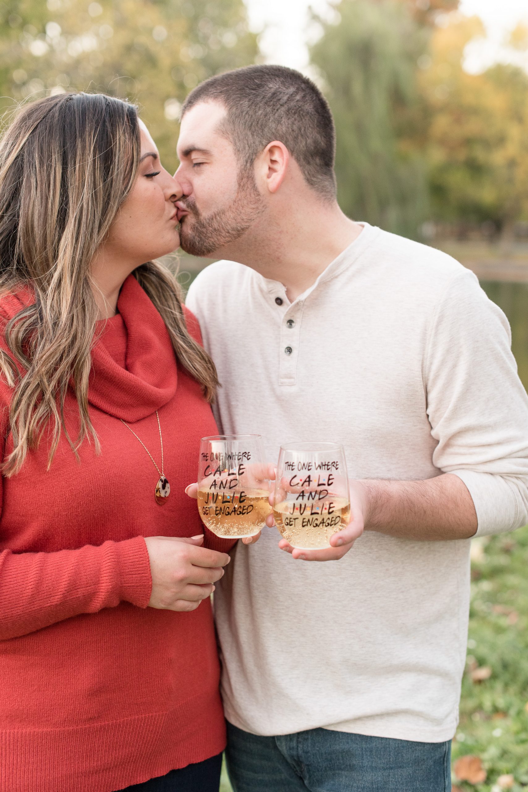 couple kissing while holding wine glasses at longs park in lancaster pennsylvania