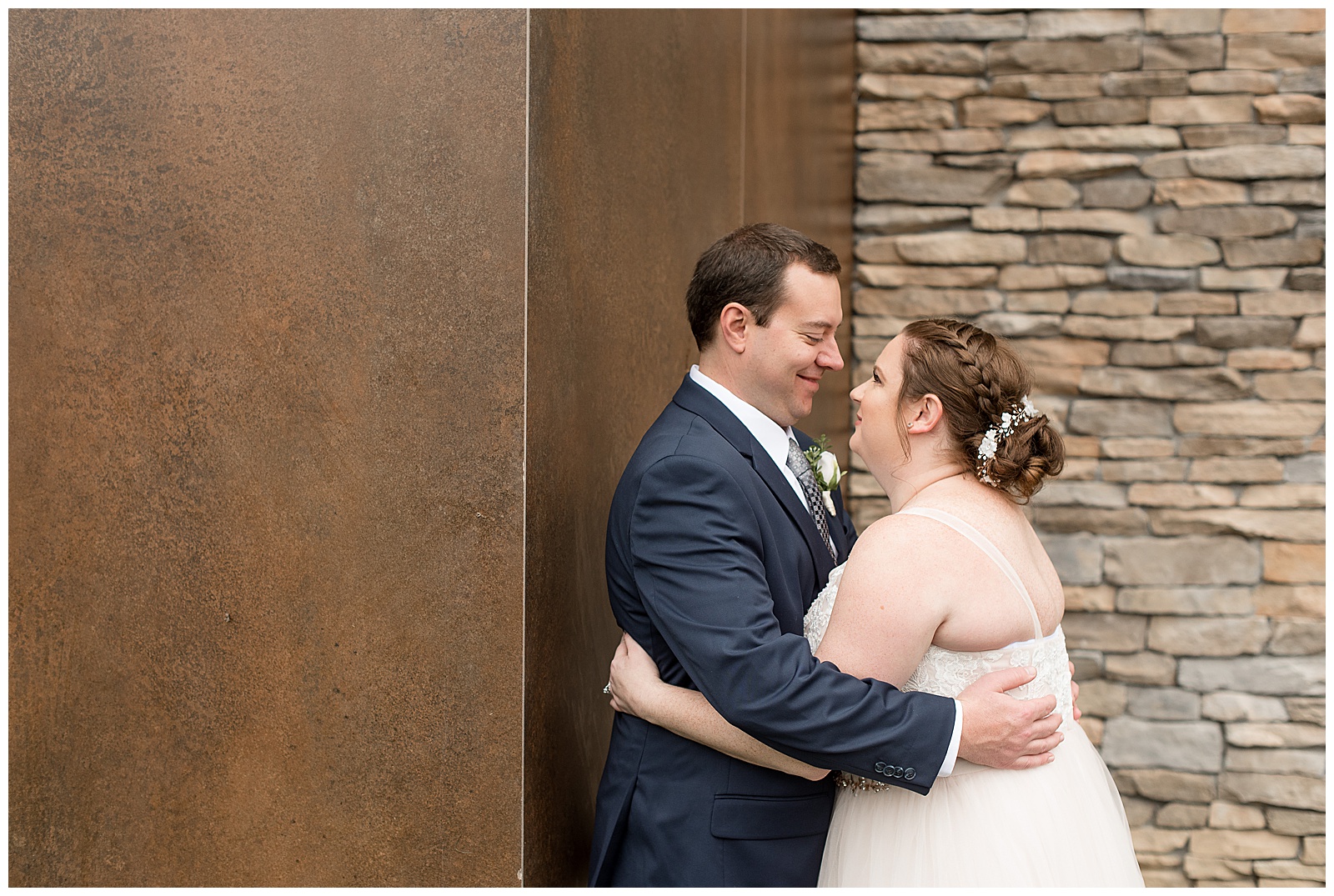couple smiling and embracing by wooden and stone walls at eden resort in lancaster pennsylvania
